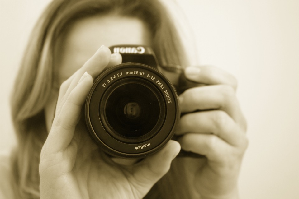 blonde girl taking a pic using Cannon DSLR